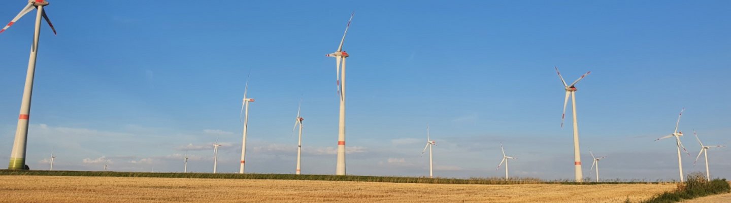 Windpark aus der Nähe vor blauem Himmel