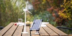 Windenergie Modell und Solar Modul auf Tisch im Garten